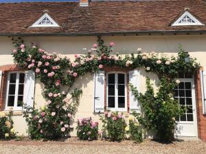 een wit huis met roze rozen erop bij Les Gelots in Villemurlin