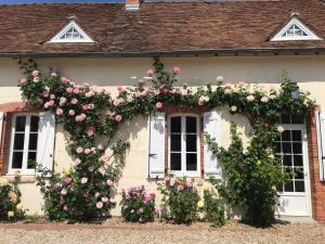 a white house with pink roses on it at Les Gelots in Villemurlin