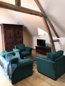 a living room with two couches and a tv at Les Gelots in Villemurlin
