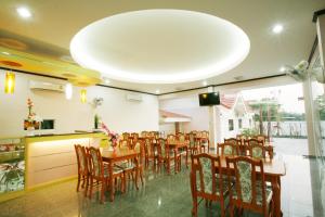 a dining room with wooden tables and chairs at Soda Resort in Kamphaeng Phet