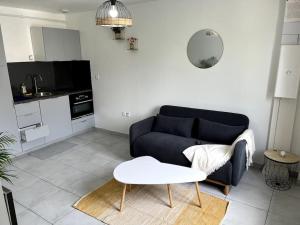 - un salon avec un canapé et une table dans l'établissement Espace privé 35 m2 à 15 min de Paris, à Groslay