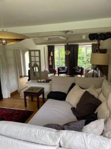 a living room with a large white couch in a room at Villa de 4 chambres avec piscine privee terrasse et wifi a Plouigneau in Plouigneau
