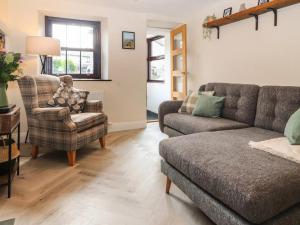 ein Wohnzimmer mit einer Couch und einem Sessel in der Unterkunft Fellside Cottage in Shap