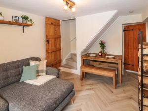 ein Wohnzimmer mit Sofa und Tisch in der Unterkunft Fellside Cottage in Shap