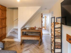 ein Wohnzimmer mit einem Holztisch und einer Treppe in der Unterkunft Fellside Cottage in Shap