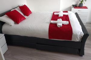 een bed met een rode en witte deken met een kruis erop bij Gresham House - London Excel in Londen