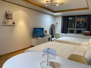 a hotel room with two beds and a tv at Serein_HongDae in Seoul