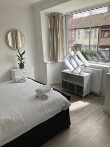 a bedroom with a bed and a large window at Gresham House - London Excel in London