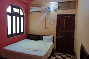 OYO Prabha Guest House في Robertsganj: غرفة صغيرة بها سرير ونافذة