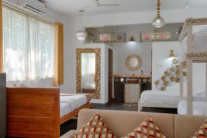 a living room with two beds and a mirror at The Singing Tree in Old Goa
