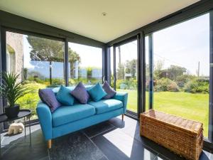 艾薩克港的住宿－Beautiful family home, sea views, large garden，带大窗户的蓝色沙发