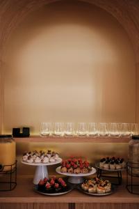 una mesa con tres platos de comida y copas de vino en Prinsotel La Caleta, en Ciutadella