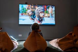 a person sitting on a couch watching a tv at Moonfleet Manor - A Luxury Family Hotel in Weymouth