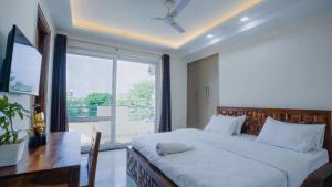 a bedroom with a bed and a desk and a window at Lime Tree Hotel Golf Course Extension Nearby Grand Hyatt Gurgaon in Gurgaon
