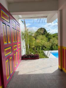 Habitación con puerta y vistas a la piscina en FINCA HOTEL EL TURPIAL, en Quimbaya