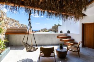 a patio with a hammock and a view of the ocean at Charisma Hotel and Wellness Suites in Plintri