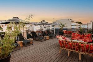 un balcone con sedie e ombrelloni sul tetto di Dave Red Athens, a member of Brown Hotels ad Atene