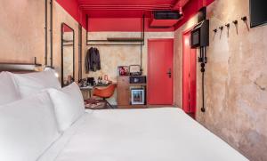 Dave Red Athens, a member of Brown Hotels في أثينا: غرفة نوم بسرير أبيض وجدران حمراء