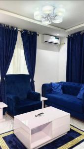 a living room with blue couches and a coffee table at 1bedroom serviced apartment in Benin City in Benin City