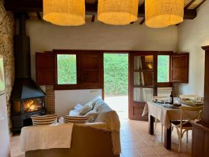 ein Wohnzimmer mit einem Kamin und einem Tisch in der Unterkunft Can LLorens in Llagostera