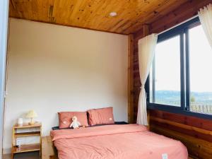 a bedroom with a bed and a large window at Lam Nguyên Farm Stay in Bao Loc