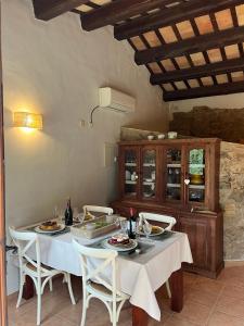 ein Esszimmer mit einem Tisch und Stühlen sowie Flaschen Wein in der Unterkunft Can LLorens in Llagostera