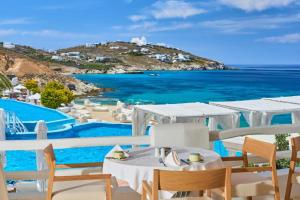 a table and chairs with a view of the ocean at Saint John Hotel Villas & Spa in Agios Ioannis Mykonos