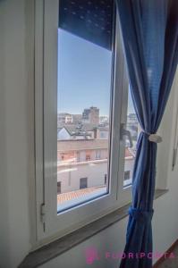 uma janela com uma cortina azul e uma vista em Borgo San Giuseppe 16 em Parma