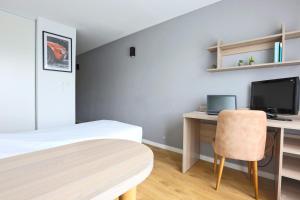 a bedroom with a desk and a bed and a table at KOSY Appart'Hôtels - La Maison Des Chercheurs in Vandoeuvre-lès-Nancy