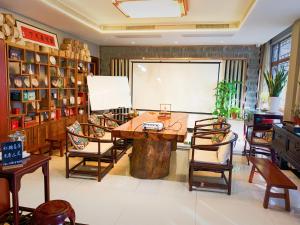 蘇州市にあるSuzhou Jade Snow Lodgeのテーブルと椅子付きの広い客室です。