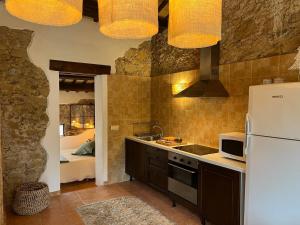 eine Küche mit einer Spüle und einem Kühlschrank sowie ein Schlafzimmer in der Unterkunft Can LLorens in Llagostera
