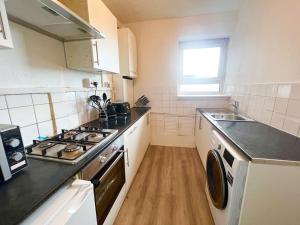 a kitchen with a sink and a stove top oven at 2 Bed- Belsize Park in London