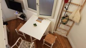 una vista aérea de una mesa y sillas en una habitación en Chambre cosy dans petit loft en París