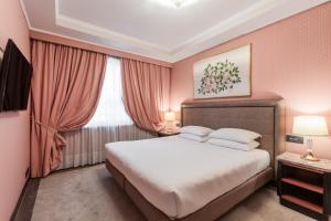 una camera con un grande letto e una finestra di Doria Grand Hotel a Milano