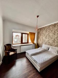 - une chambre avec un lit, une chaise et une fenêtre dans l'établissement Cazino Maritim Residence, à Constanţa