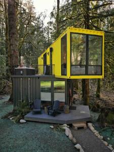 una casa en un árbol amarillo en medio de un bosque en The Sea Containers, en Index