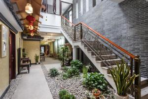 une cour intérieure d'un immeuble avec des escaliers et des plantes dans l'établissement Suzhou Jade Snow Lodge, à Suzhou