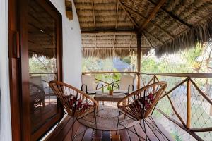 Zimmer mit einem Tisch und Stühlen auf einem Balkon in der Unterkunft Bangalô da Barra, chalé 04 - BG in Barra Grande