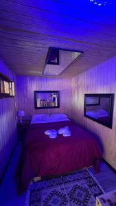 Un dormitorio con una cama con luces moradas. en Paradise Rose’s, en Talagante