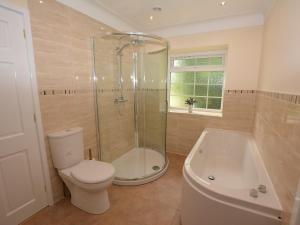 uma casa de banho com um chuveiro, um WC e uma banheira em 3 Bed in Llangollen 39974 em Overton