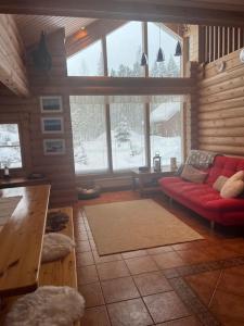a living room with a red couch in a cabin at Holiday home with lake view and next to National Park in Kolinkylä