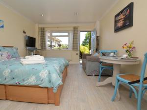 a bedroom with a bed and a table and chairs at 1 Bed in Charmouth 41890 in Charmouth