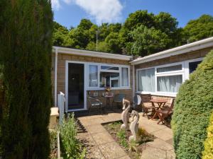 a house with a patio with a table and chairs at 1 Bed in Charmouth 41890 in Charmouth