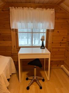 a desk in a room with a bed and a window at Holiday home with lake view and next to National Park in Kolinkylä