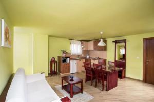 a living room with a white couch and a kitchen at Pilvax Apartment in Braşov