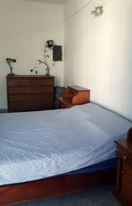 a bedroom with a blue bed and a dresser at Departamento céntrico in San Lorenzo