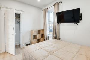 1 dormitorio con 1 cama y TV de pantalla plana en la pared en Cozy Rustic Newark Apt 2 Mi to Prudential Center!, en Newark