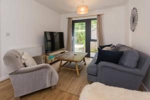 a living room with two couches and a tv at Convenient Totnes Town Centre Family Home with Parking 2 bedrooms in Dean