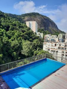 a swimming pool on top of a building with a mountain at Royalty Copacabana Hotel in Rio de Janeiro