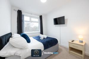 um quarto com uma cama e uma janela em Luxurious & Spacious 2 Bedroom Home By Opuluxe Properties Short Lets & Serviced Accommodation Near Manchester City Center em Manchester